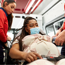 A pregnant person is transferred into an ambulance for care.