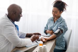 A doctor measures a pregnant person's blood pressure.